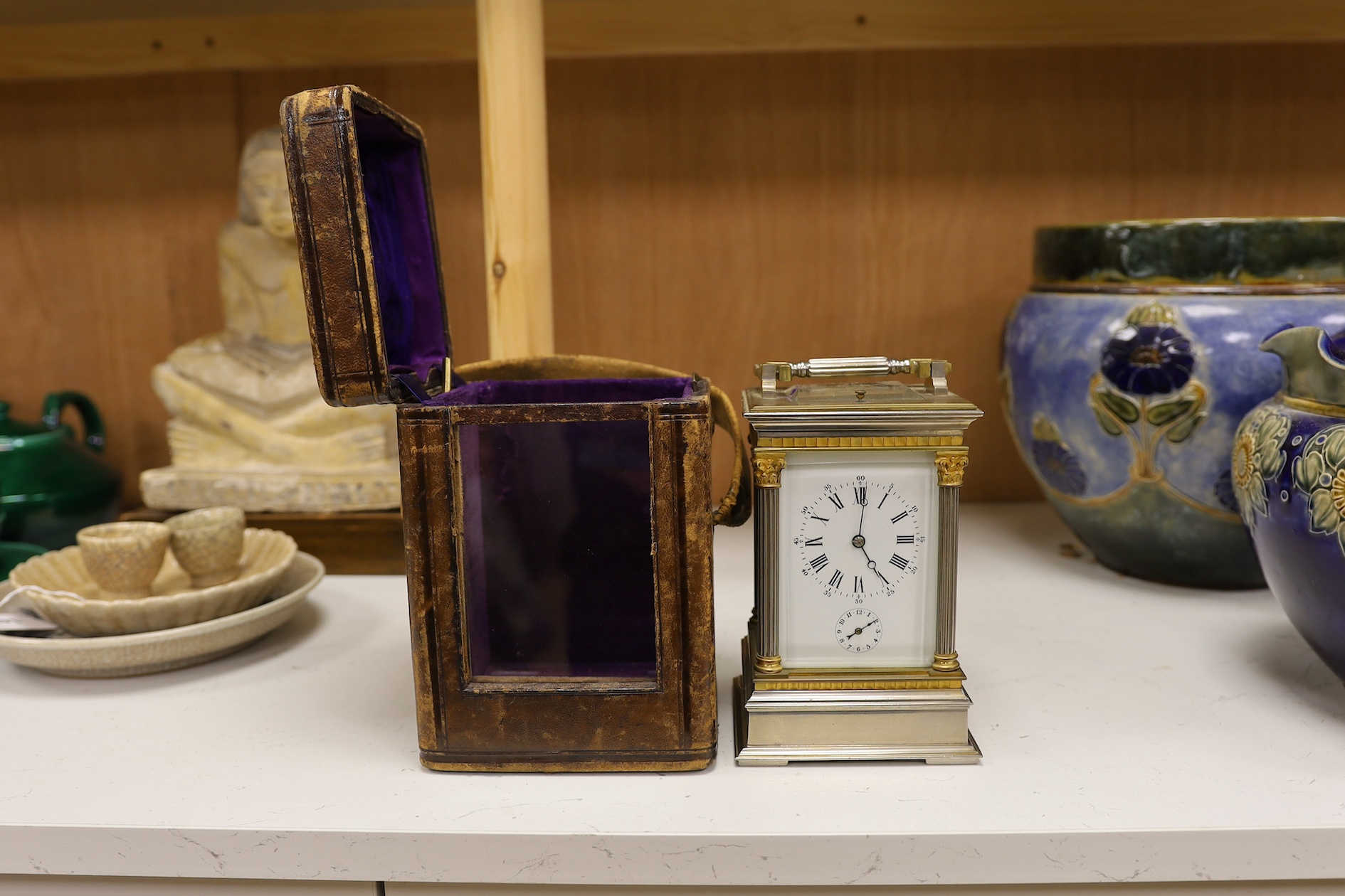 A carriage clock, in leather case, 18cm high. Condition - gilding worn and surface slightly pitted in places